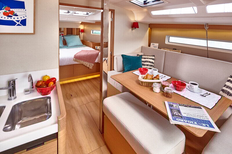 Sun Odyssey 440:n avara ja valoisa salonki, jossa mukavat istuinryhmät ja tyylikäs puuviimeistely.