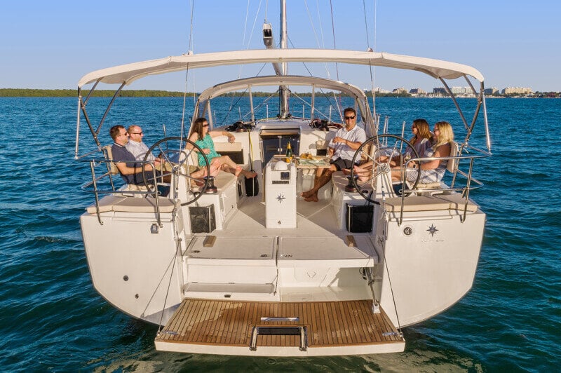 Sun Odyssey 490 - purjeveneen sitlooda merellä, jossa seurue nostaa maljan upealle purjehduselämykselle.
