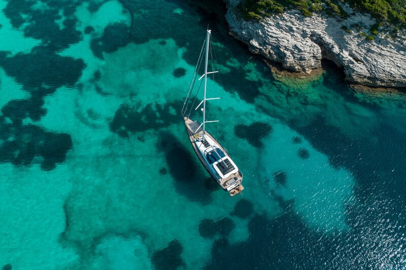 Jeanneau Yachts 65 ankkurissa turkoosissa vedessä, uimataso laskettuna.