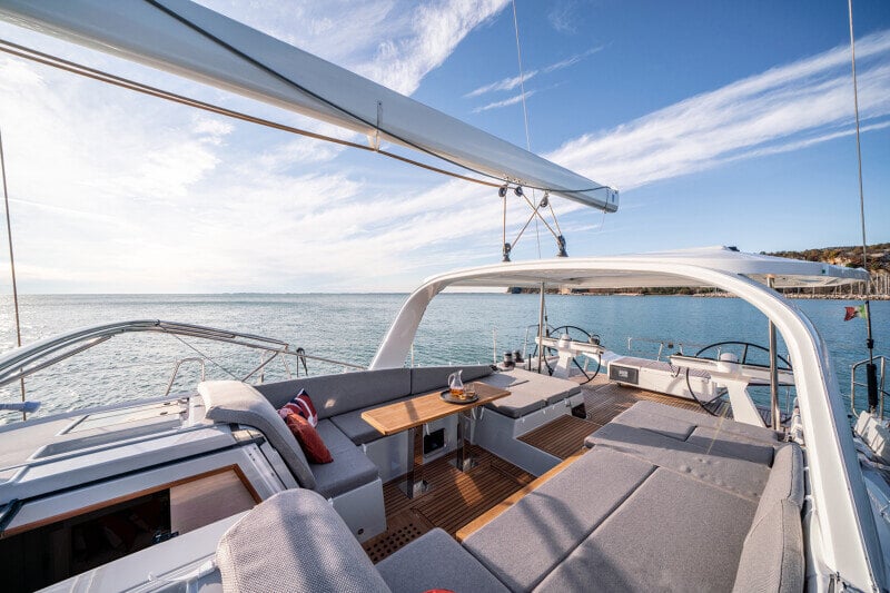 Jeanneau Yachts 65 veneilemässä saariston halki, sininen taivas ja rauhalliset vedet.