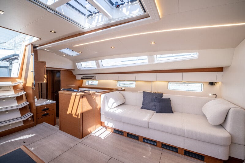Jeanneau Yachts 65 -veneen salonki iltavalaistuksessa, lämmin ja tunnelmallinen.